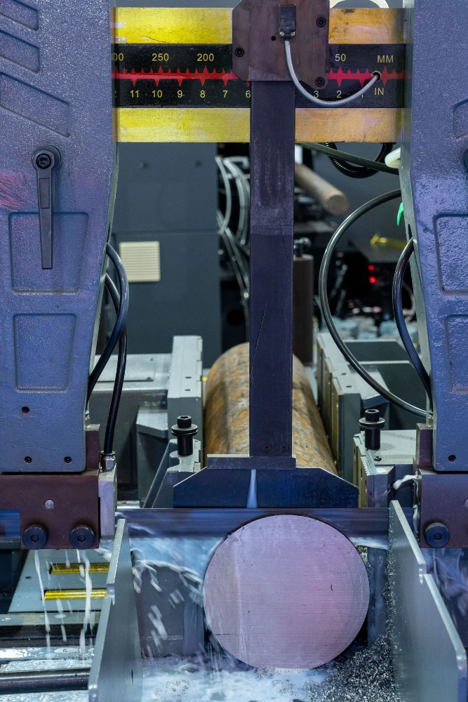 Bandsaw cutting alloy steel round bar at Sai International